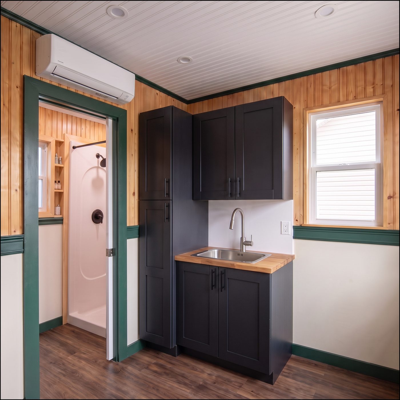 Classic 160 kitchen with near-black cabinets, a butcher block counter and a mini split head above the bath door