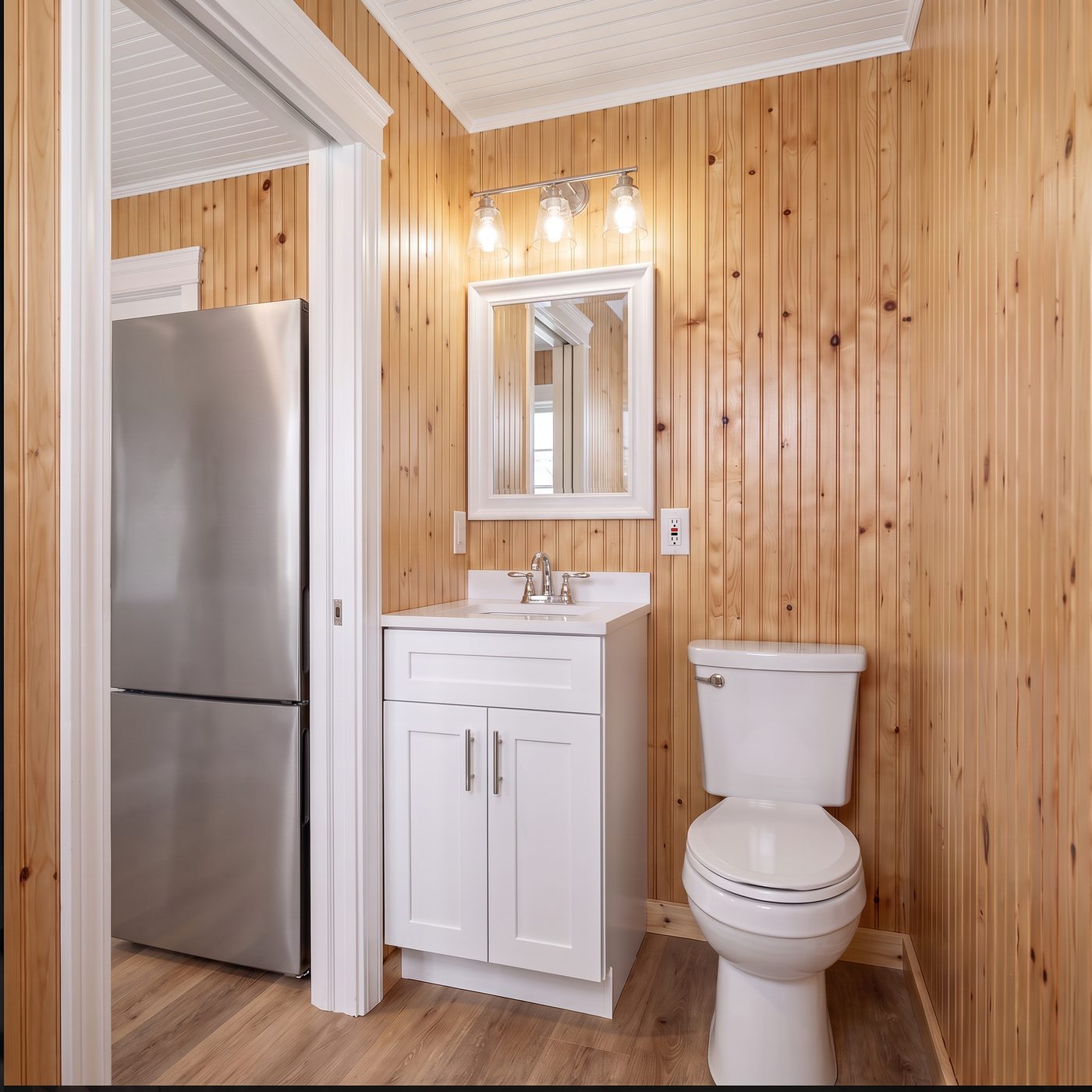Comfort 160 bath with a white shaker vanity, mirror and light bar